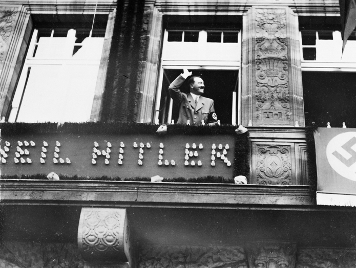 Adolf Hitler salutes the crowd from the balcony of Hotel Deutscher Hof in Nuremberg at the start of the 1934 Reichsparteitag